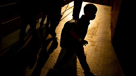 A student arrives as the sun rises during the first day of school.