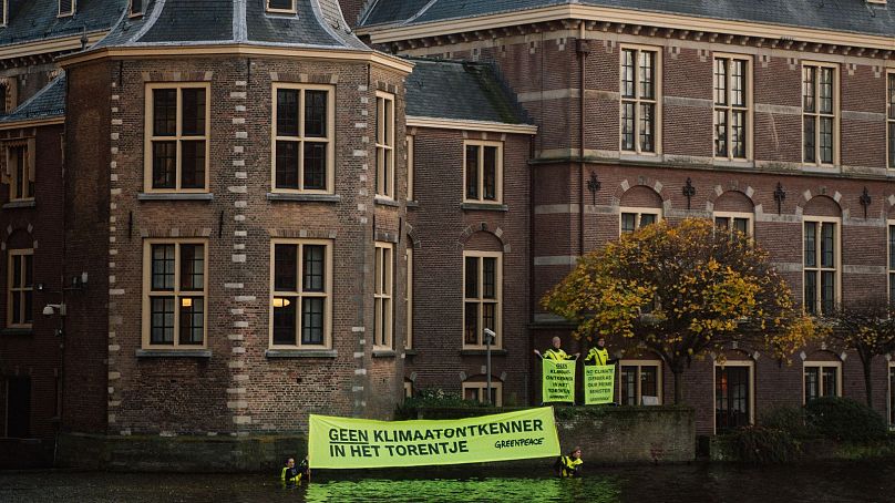Greenpeace activists unfurled a banner below the prime minister's office and outgoing PM Mark Rutte opened the window to speak with them briefly.