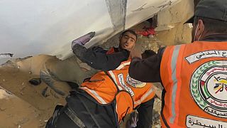 عمال الإنقاذ يحاولون انتشال صحفي من تحت أنقاض مبنى مدمر 