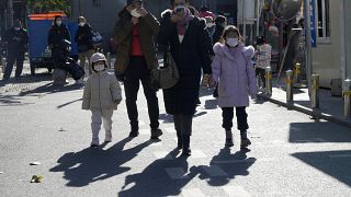 Maskierte Anwohner gehen an einem chinesischen Kinderkrankenhaus in Peking vorbei, Freitag, 24. November 2023.