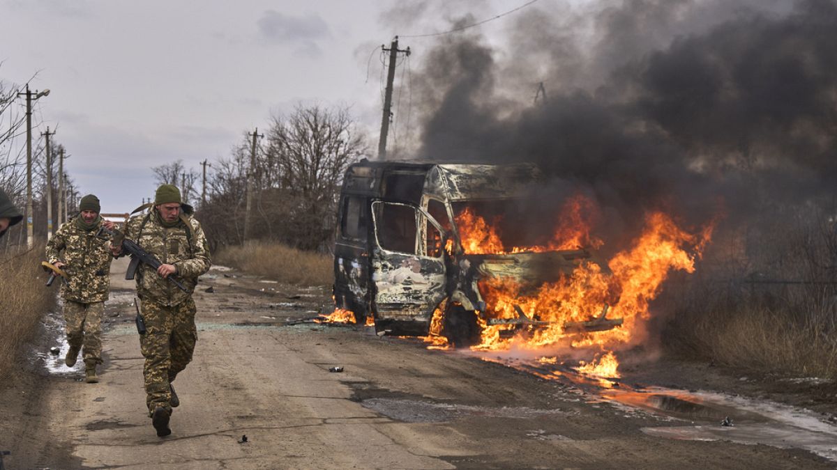 Украинские солдаты автобуса добровольцев, горящего после попадания в него российского беспилотника возле Бахмута, Донецкая область, Украина, четверг, 23 ноября 2023 года