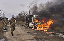 Украинские солдаты автобуса добровольцев, горящего после попадания в него российского беспилотника возле Бахмута, Донецкая область, Украина, четверг, 23 ноября 2023 года