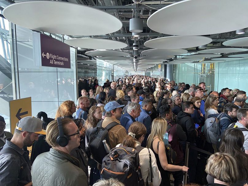 People queue at arrivals at Heathrow airport in London, May 2023