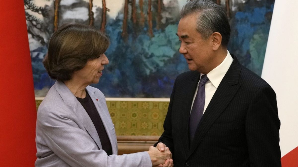 Chinese Foreign Minister Wang Yi, right, shakes hands with French Foreign Minister Catherine Colonna at the Diaoyutai State Guesthouse in Beijing.