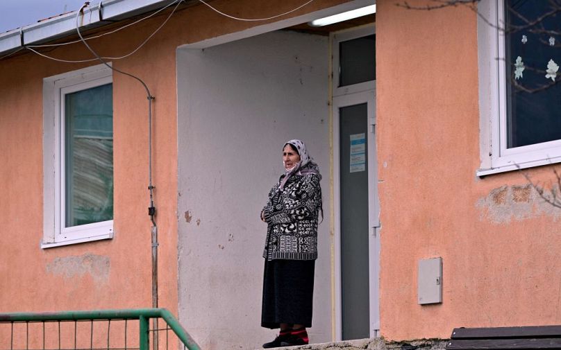 An elderly Palestinian refugee woman stands in front of her accommodation at a refugee centre, in Salakovac, Bosnia