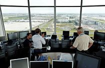 An air-traffic controller (right) speaks with visitors in the main control tower at the Charles de Gaulle International Airport in Roissy, near Paris, September 2014. 