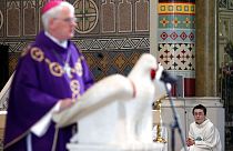 A alter boy listens to Bishop Noel Treanor, during mass at St Peter's Roman Catholic Cathedral in West Belfast, Northern Ireland, Sunday, March, 21, 2010. 