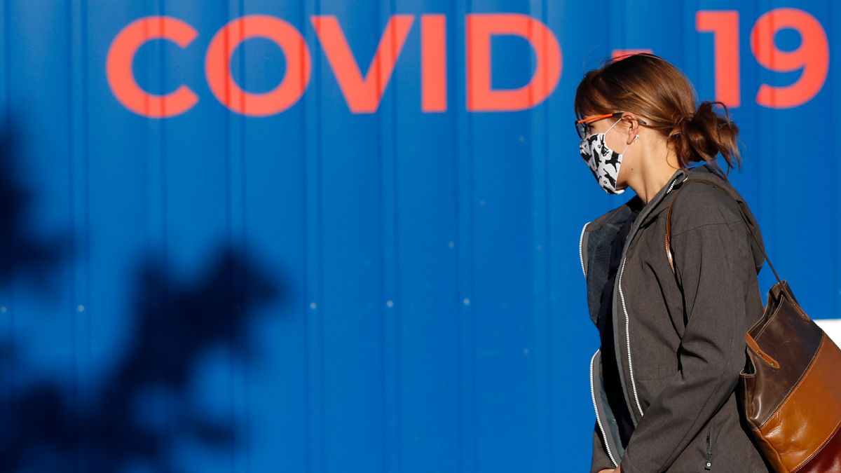 A woman wearing a face mask walks to get tested for COVID-19 in Prague, Czech Republic.