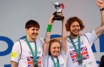 Members of team UK pose with their victory trophy at an award ceremony during a trash picking competition known as "Spogomi World Cup" in Tokyo.