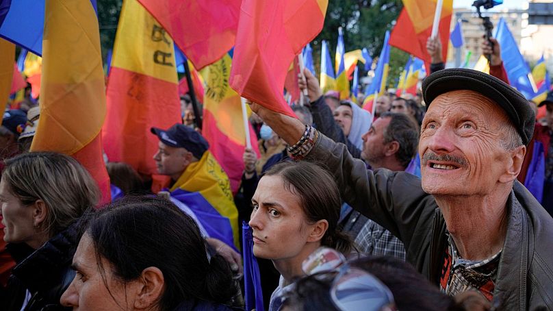 Des personnes agitent des drapeaux lors d'une manifestation anti-gouvernementale organisée par l'Alliance pour l'unité des Roumains (AUR), à Bucarest