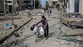 A boy carries salvageable items on his bicycle as Palestinians leave Gaza City to safer areas in the south on Saturday