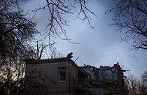 Un militaire ukrainien se tient au-dessus d'un jardin d'enfants endommagé à la suite d'une attaque de drone russe à Kiev, en Ukraine, le samedi 25 novembre 2023.