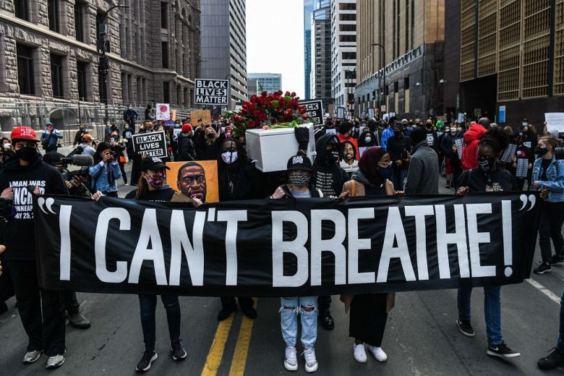 Demonstrators hold placards during the I Cant Breathe - Silent March for Justice in front of the Hennepin County Government Centre in March 2021