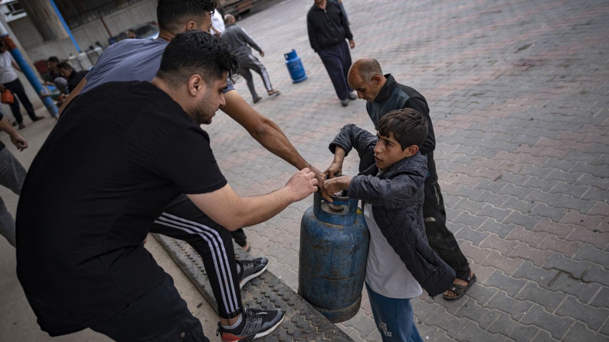Palestinianos fazem fila para encher botijas de gás, durante cessar-fogo, em Khan Younis, na Faixa de Gaza