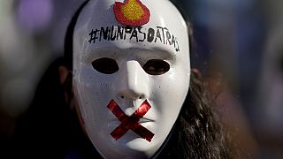 Manifestante usa máscara com a mensagem "Nem um passo atrás", durante protesto, em Buenos Aires, contra a violência de género na Argentina