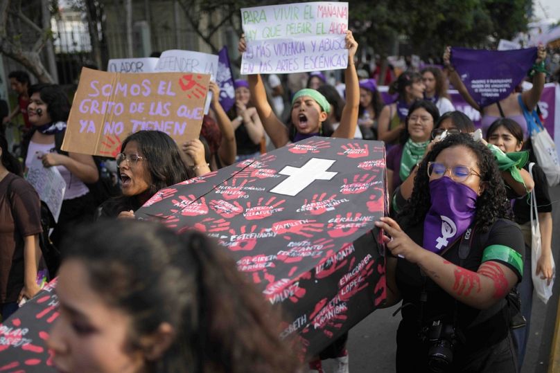 Γυναίκες κουβαλούν ένα ψευτικο φέρετρο με τα ονόματα των θυμάτων έμφυλης βίας, κατά τη διάρκεια μιας πορείας στο Περού
