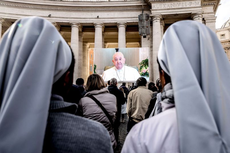 Faithful gather in St. Peter's Square to support Pope Francis as he presides the Angelus prayer from Santa Marta Chapel due to a lung inflammation on Sunday