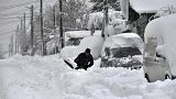 Un hombre quita la nieve con una pala, al lado de su coche, en la ciudad de Isperih, en el nordeste de Bulgaria, el domingo 26 de noviembre de 2023.