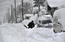 Un hombre quita la nieve con una pala, al lado de su coche, en la ciudad de Isperih, en el nordeste de Bulgaria, el domingo 26 de noviembre de 2023.