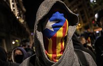 Un hombre se cubre la cara con una 'estela', la bandera independentista catalana