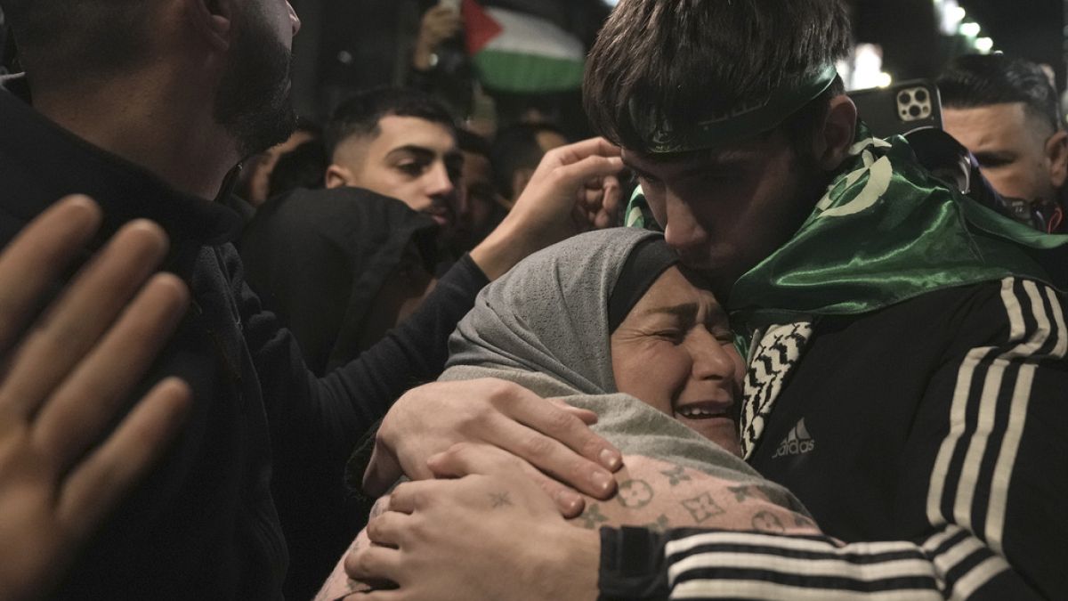 Omar Atshan, 17 anos, é abraçado pela sua mãe depois de ter sido libertado de uma prisão israelita na cidade de Ramallah, na Cisjordânia, no domingo