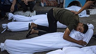 Palestinians mourn their relatives killed in the Israeli bombardment of the Gaza Strip, in front of the morgue in Deir al Balah, Wednesday, Nov. 1, 2023.