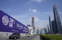 Autók haladnak el a COP28-at hirdető óriásplakát mellett a Sheikh Zayed autópályán Dubajban, az Egyesült Arab Emírségekben, 2023. november 27-én, hétfőn.