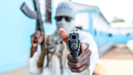 A Togolese policeman, disguised as a terrorist, brandishes his weapon on October 20, 2022 during an anti-terrorism exercise at the Peacekeeping Operations Training Center.