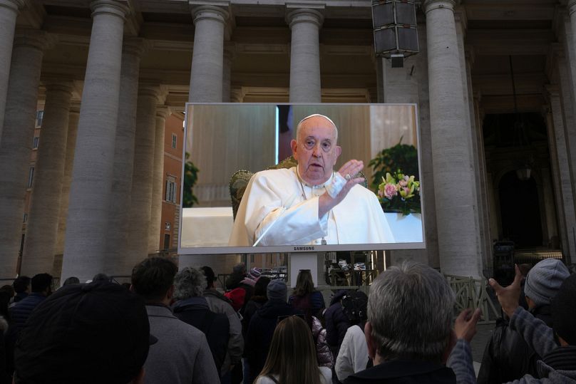 A giant screen broadcasts Pope Francis delivering his blessing during the Angelus noon prayer from the chapel of the hotel at the Vatican grounds where he lives, Sunday, Nov.