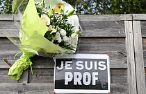 Flowers next to a placard reading "I am a teacher" in tribute to Samuel Paty, the history-geography teacher who was beheaded on Oct. 16, 2020