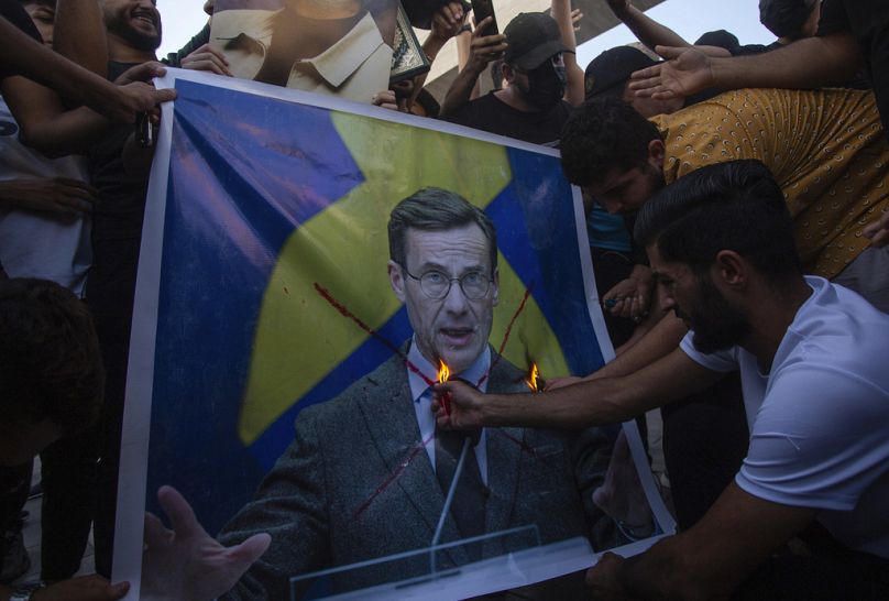 Iraqis burns the picture of Sweden's prime Ulf Kristersson, during a protest in Tahrir Square.
