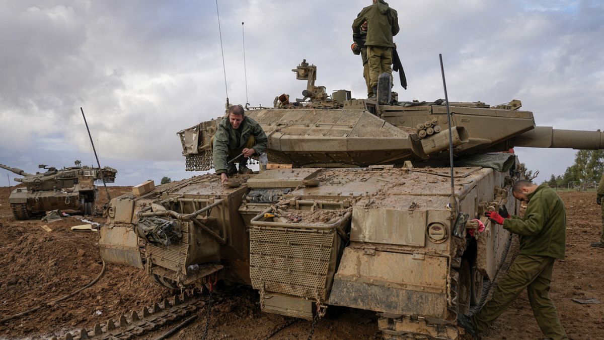 Izraeli katonák egy harckocsin dolgoznak a gázai határ közelében 2023. november 27-én