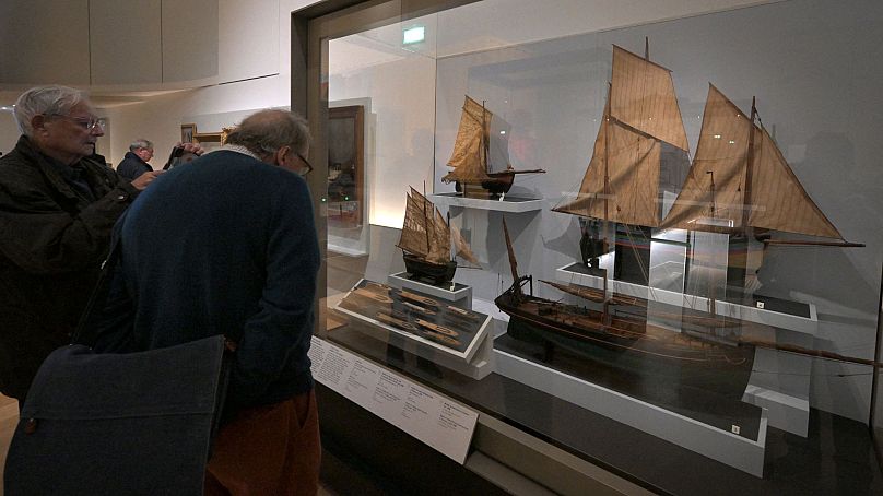 People look at models of vintage fishing boats displayed at the French National Navy museum is pictured in Paris, on 16 November 2023.