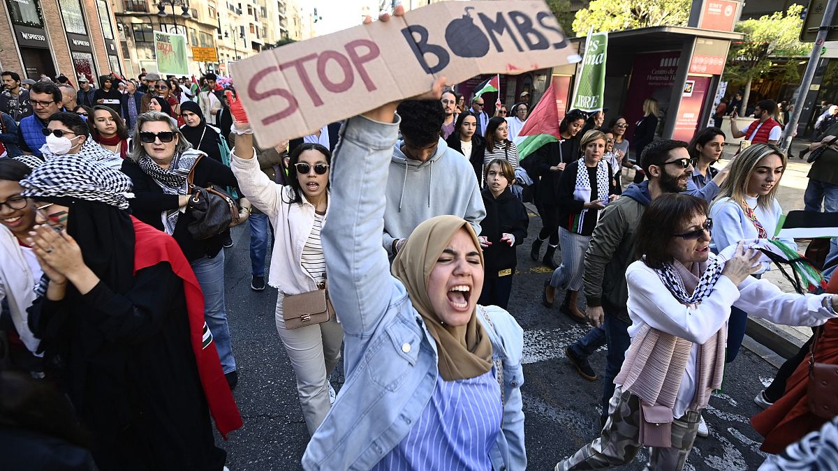 Bir gösterici 19.11 tarihinde Valensiya'da Filistin halkına destek için düzenlenen bir gösteri sırasında "Bombaları durdurun" yazılı bir pankart tutarak slogan atıyor.