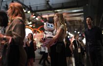 A woman carries a robot during the Vivatech show in Paris, France, Wednesday, June 14, 2023.