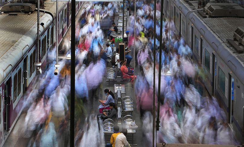 سيدة تجلس على مقعد في محطة قطار خلال ساعات الذروة في مومباي، الهند