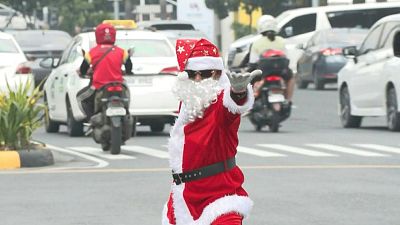  الفلبيني راميرو هينوخاس يرتدي زي "سانتا كلوز" يوجه تدفق المركبات وهو يرقص على طول تقاطع مزدحم في ضواحي باساي، جنوب مانيلا عاصمة الفلبين.