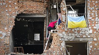 Bewohner versuchen ihr Eigentum aus einem zerstörten Wohnhaus in Kiew zu bergen.
