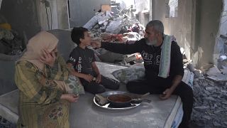 عائلة فلسطينية تتغذى على وجبة من الطماطم والخبز في غزة