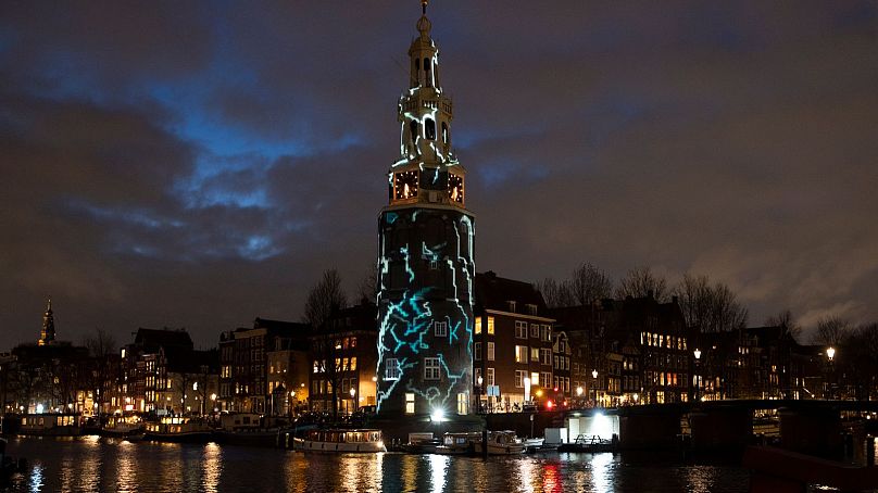 A light art work titled "The Cracks" by Karolina Howorko is projected on Montelbaan's tower during the Amsterdam Light Festival, 2019.