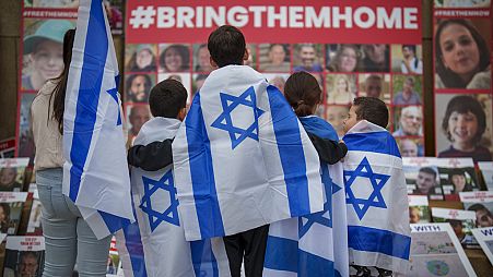 FILE - Children look at photographs of kidnapped Israelis during a rally joined by hundreds in solidarity with Israel and those held hostage in Gaza, in Romania 2/11/23.