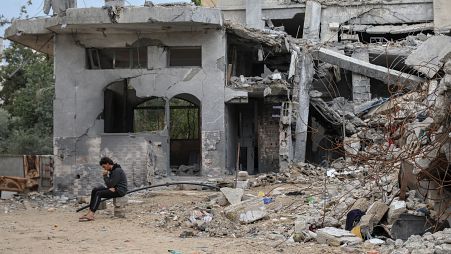 شاب فلسطيني يجلس أمام منزل ذويه المدمر جراء القصف الإسرائيلي في جباليا في غزة