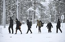 Finnish Border Guards escort migrants arriving at the Raja-Jooseppi international border crossing station between Russia and Finland, in Inari, northern Finland,  25/11/23.