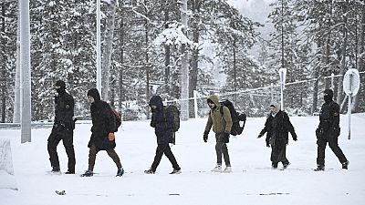 Finnish Border Guards escort migrants arriving at the Raja-Jooseppi international border crossing station between Russia and Finland, in Inari, northern Finland,  25/11/23.