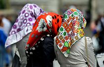 Three women wearing colourful headscarves