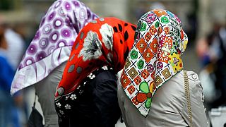 Three women wearing colourful headscarves