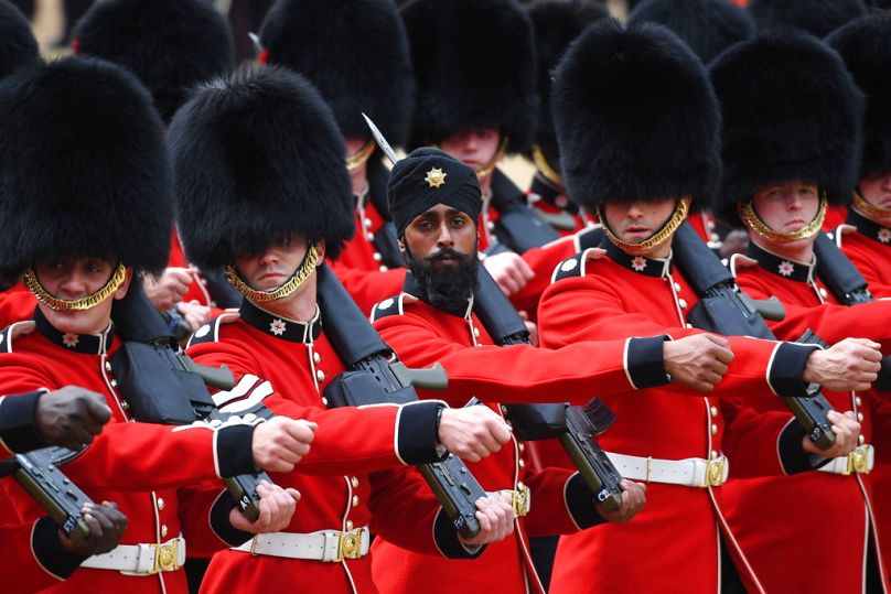 FILE: A Sikh member of the Coldstream Guards, center, wears a turban as he takes part in the Colonel's Review, London, June 2018