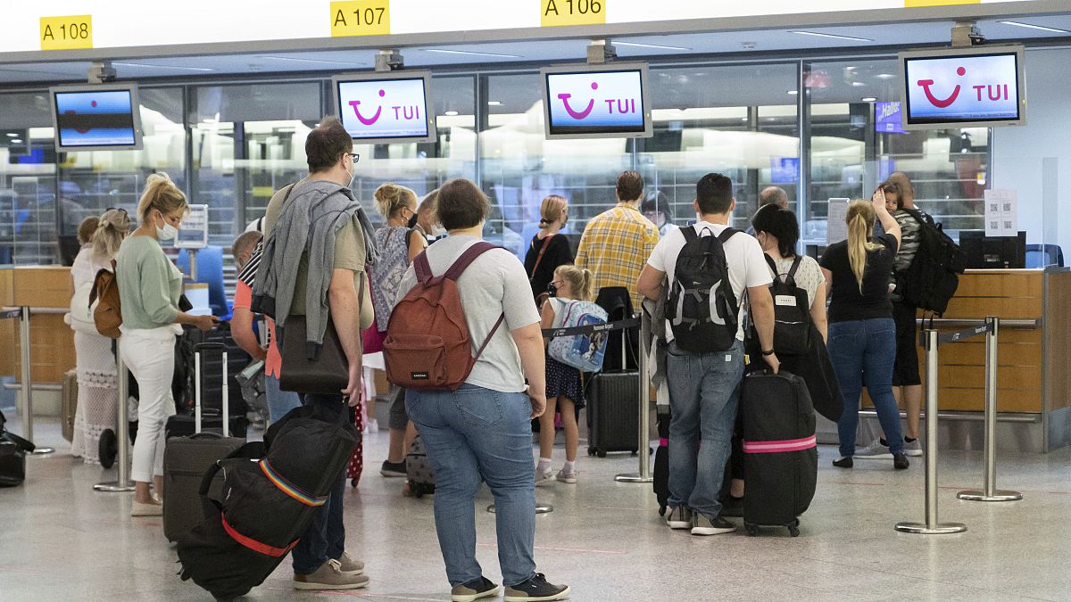 Passengers with Mallorca as their destination are available to hand in their luggage at TUI check-in counters at the airport in Hanover, Germany.