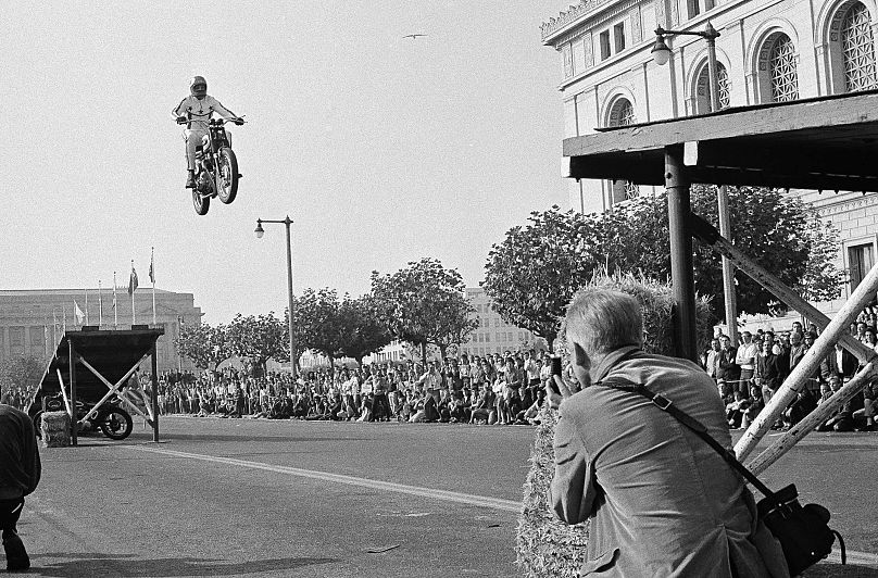 Evel Knievel, jumps his cycle between two ramps, a hundred feet apart, to open a Sports Cycle Exhibition at the Civic Center, Nov. 23, 1967, San Francisco