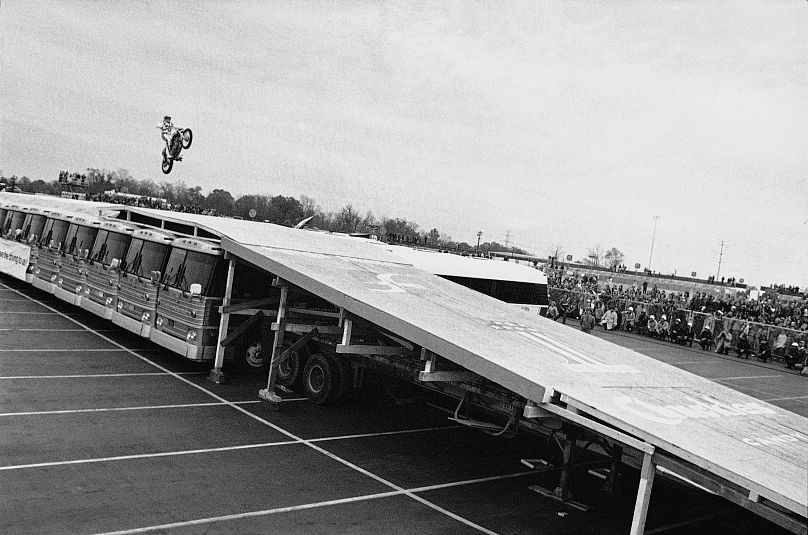 Evel Knievel lands on the rear wheel of his motorcycle to successfully complete a 14-bus jump at Kings Mills, Ohio, Oct. 25, 1975.